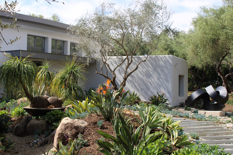 Photo of a large mediterranean front yard partial sun xeriscape in Santa Barbara with with path and natural stone pavers.