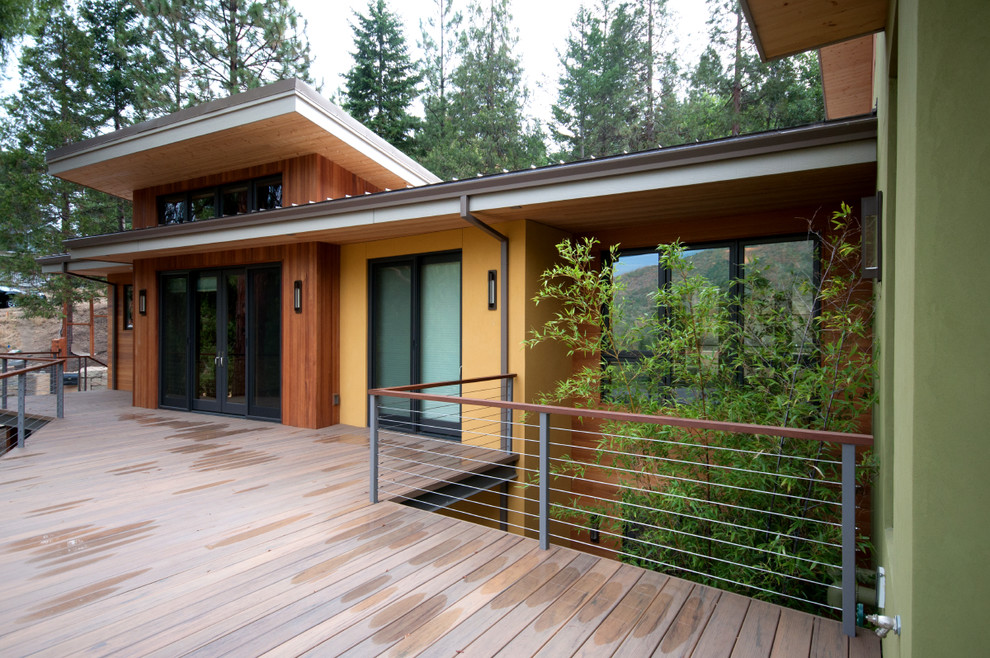 Large trendy deck photo with a roof extension