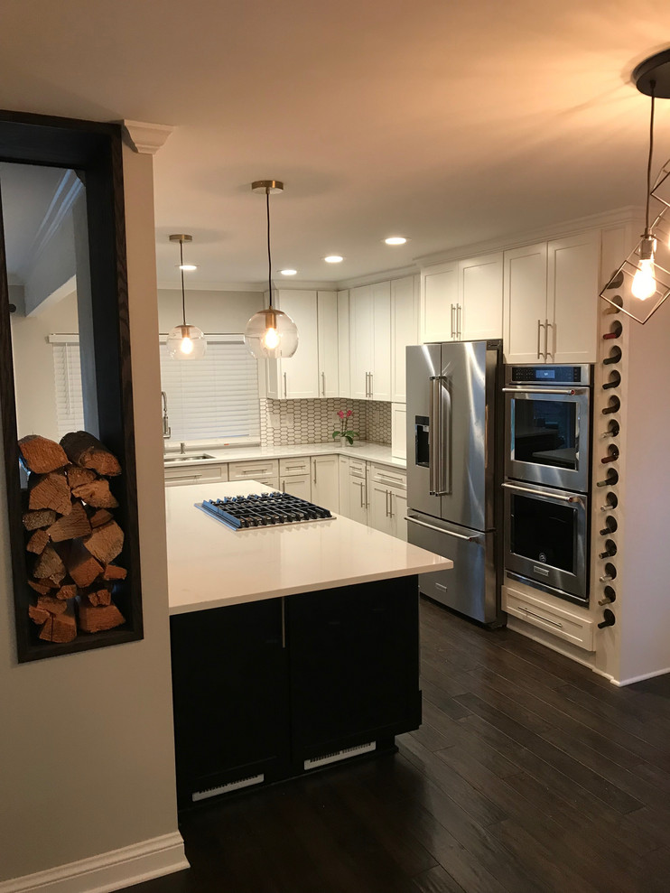 Example of a small transitional l-shaped dark wood floor and brown floor open concept kitchen design in Birmingham with shaker cabinets, white cabinets, white backsplash, stainless steel appliances, an island and white countertops