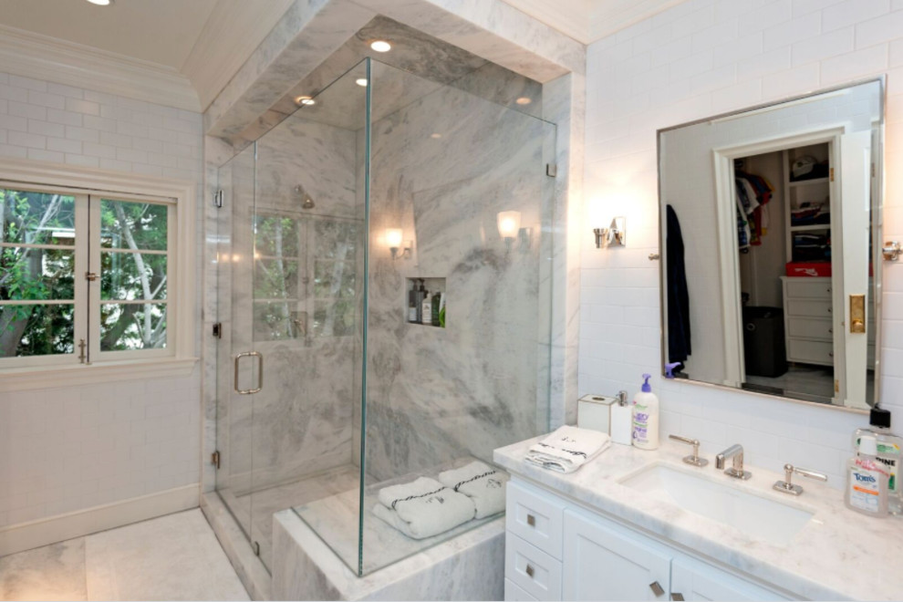 This is an example of a large transitional bathroom in Los Angeles with shaker cabinets, white cabinets, a corner shower, subway tile, white walls, an undermount sink, quartzite benchtops, a hinged shower door and pink benchtops.