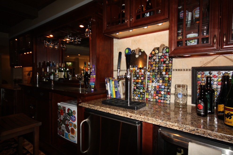 Inspiration for a large country galley seated home bar in DC Metro with an undermount sink, dark wood cabinets, granite benchtops, beige splashback, stone tile splashback and dark hardwood floors.