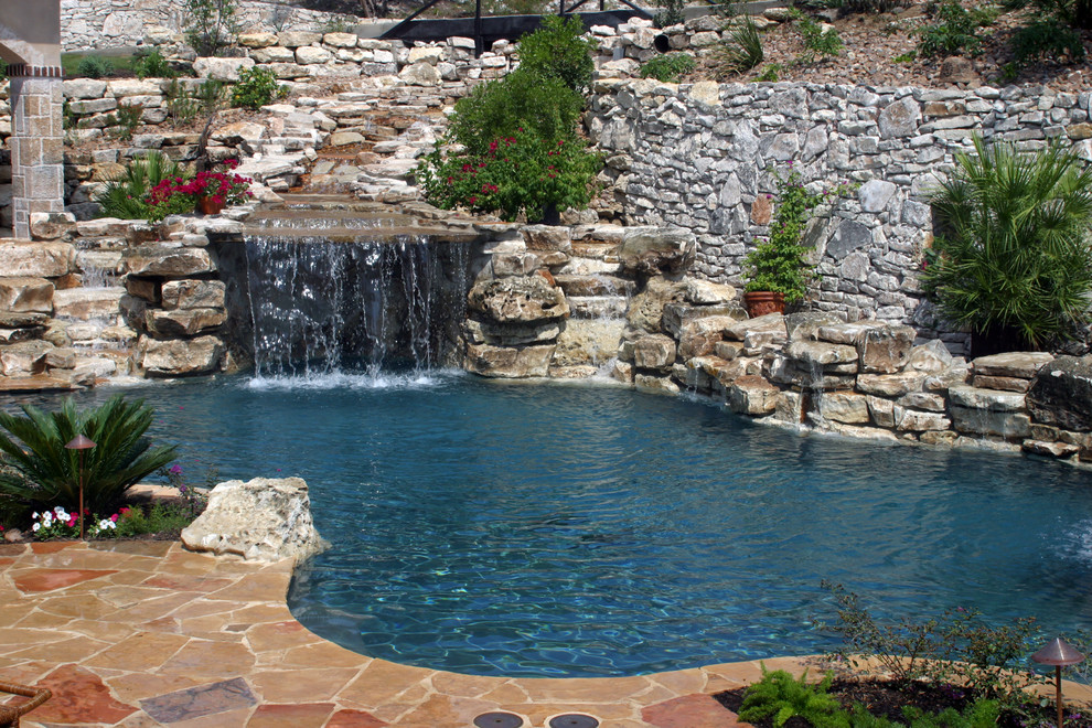 Large beach style backyard stone and custom-shaped hot tub photo in Austin