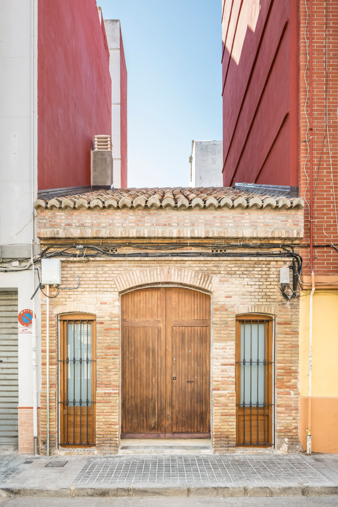 バレンシアにある小さな地中海スタイルのおしゃれな家の外観 (レンガサイディング、タウンハウス) の写真