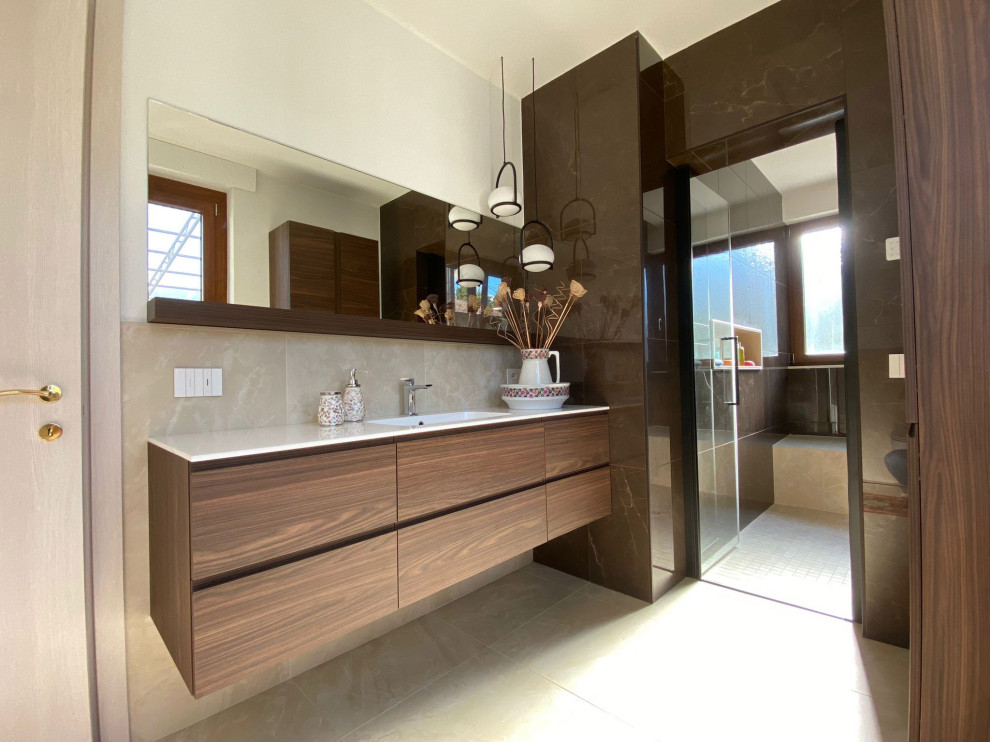Photo of a large classic ensuite wet room bathroom in Other with flat-panel cabinets, dark wood cabinets, a two-piece toilet, beige tiles, porcelain tiles, brown walls, porcelain flooring, a console sink, engineered stone worktops, beige floors, a hinged door, white worktops, a shower bench, a single sink, a floating vanity unit and a drop ceiling.
