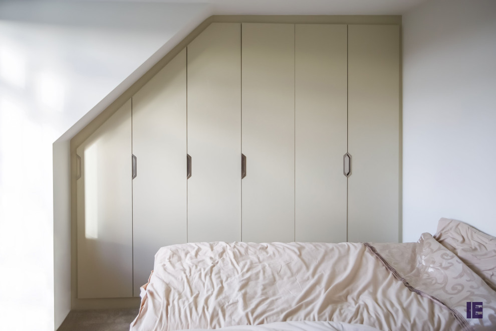Inspiration pour une grande armoire encastrée minimaliste avec un placard à porte plane.