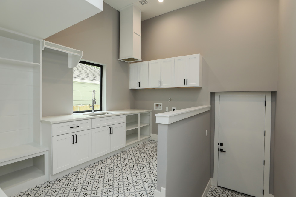 Inspiration for a large country u-shaped dedicated laundry room in Houston with an utility sink, shaker cabinets, white cabinets, quartzite benchtops, grey walls, porcelain floors, a side-by-side washer and dryer, multi-coloured floor and white benchtop.