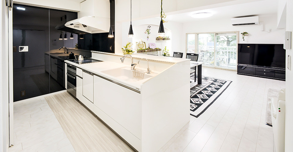 Inspiration for a mediterranean kitchen in Other with white cabinets, solid surface benchtops, black splashback, a peninsula and white benchtop.