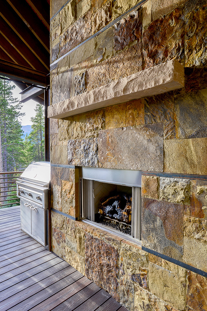 Outdoor kitchen deck - large rustic backyard outdoor kitchen deck idea in Denver with a roof extension