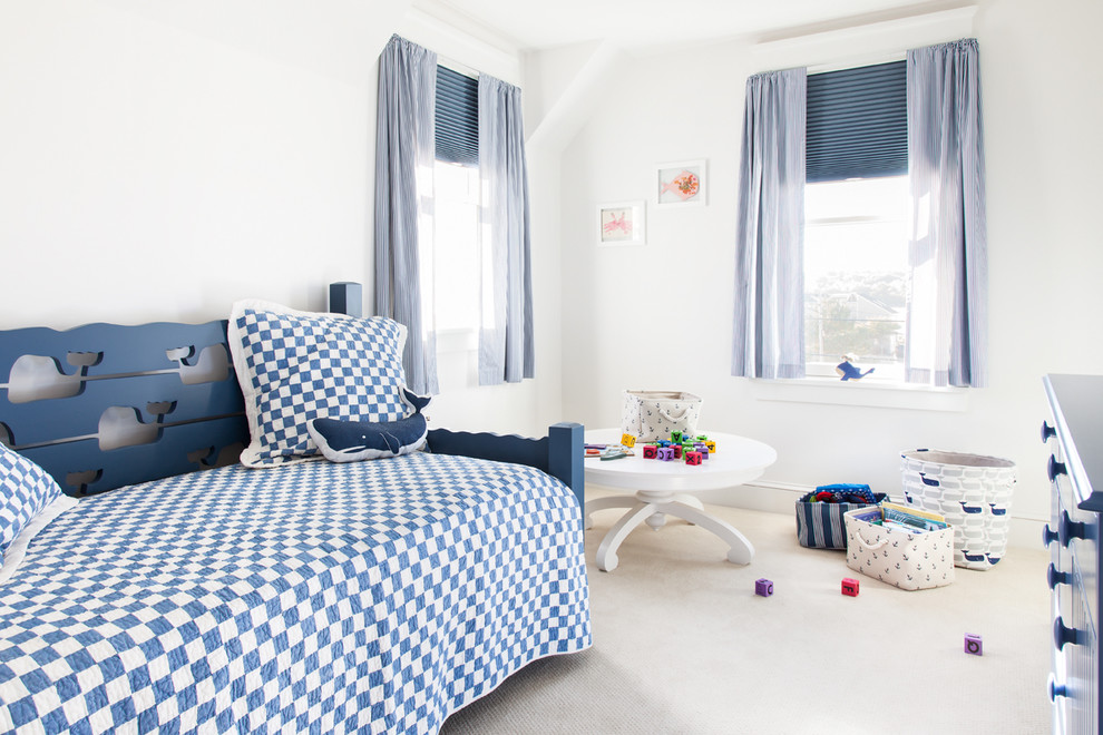 This is an example of a beach style gender-neutral kids' bedroom in Portland Maine with white walls, carpet and beige floor.