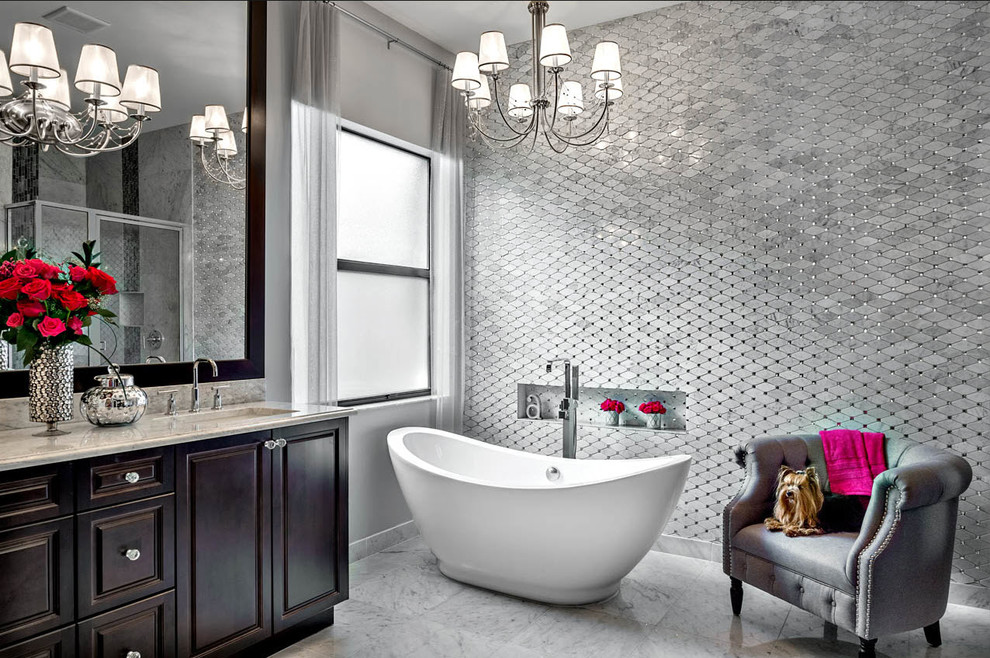 Design ideas for a large transitional master bathroom in Miami with raised-panel cabinets, dark wood cabinets, a freestanding tub, gray tile, stone tile, grey walls, marble floors, marble benchtops and an undermount sink.