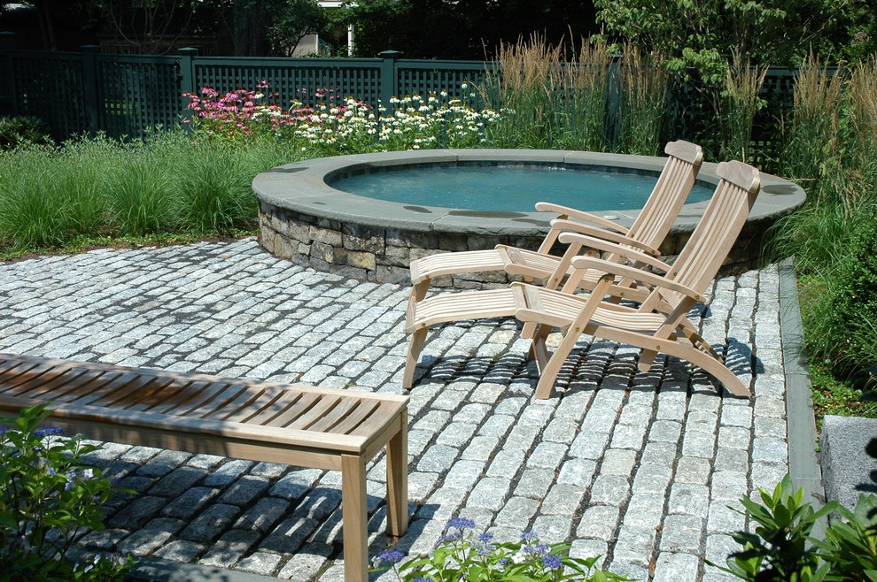 Country pool in Boston with a hot tub and brick pavers.