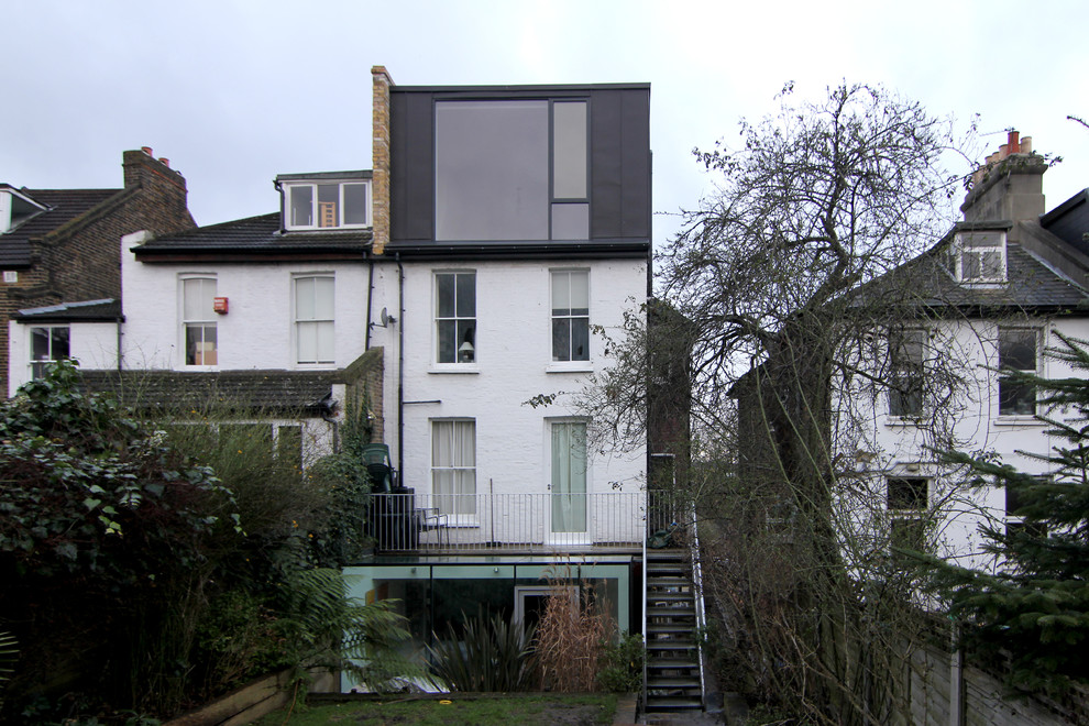 Inspiration for a mid-sized contemporary three-storey grey duplex exterior in London with metal siding, a flat roof and a tile roof.