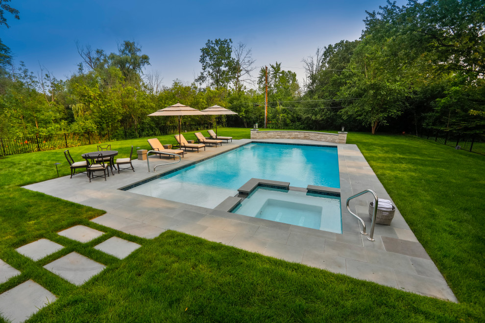 Design ideas for a mid-sized traditional backyard rectangular lap pool in Chicago with with privacy feature and natural stone pavers.
