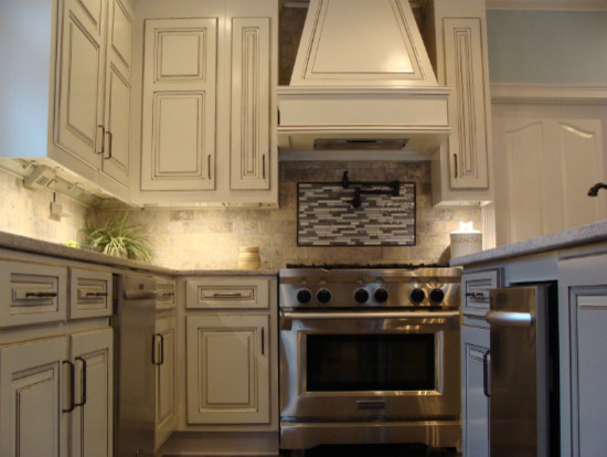 Inspiration for a transitional ceramic tile kitchen remodel with an undermount sink, raised-panel cabinets, white cabinets, solid surface countertops, subway tile backsplash, stainless steel appliances and an island