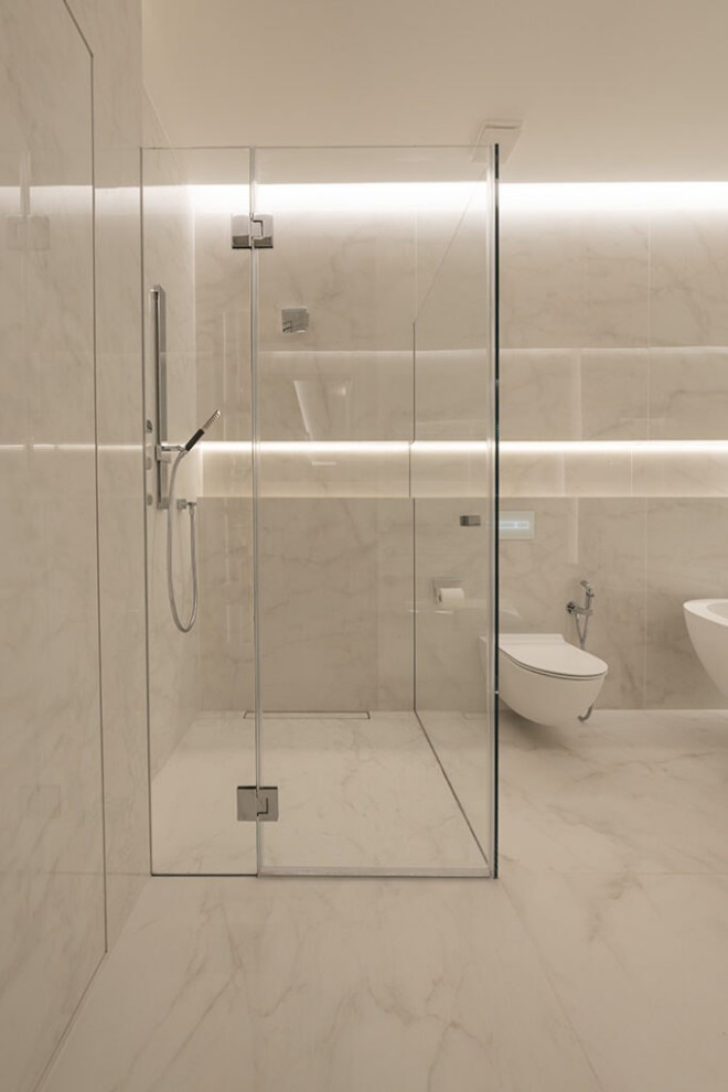 This is an example of a large modern master bathroom in London with open cabinets, white cabinets, a drop-in tub, a shower/bathtub combo, a bidet, white tile, glass tile, white walls, ceramic floors, a drop-in sink, stainless steel benchtops, white floor, a hinged shower door, grey benchtops, a single vanity, a floating vanity, wood and decorative wall panelling.