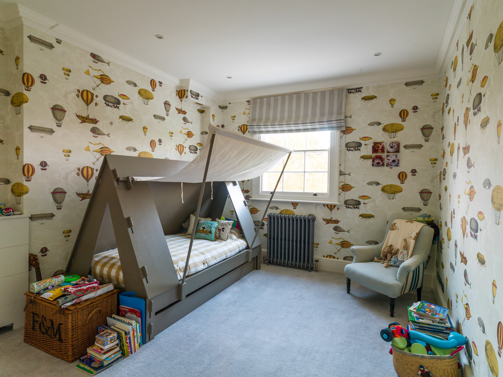 This is an example of a mid-sized transitional kids' bedroom for kids 4-10 years old and boys in London with beige walls, carpet and grey floor.