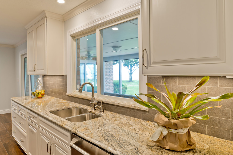Large transitional galley porcelain tile eat-in kitchen photo in Miami with an undermount sink, raised-panel cabinets, white cabinets, granite countertops, gray backsplash, porcelain backsplash, stainless steel appliances and an island