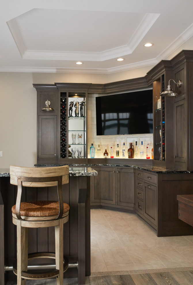 Design ideas for a beach style l-shaped home bar in Grand Rapids with dark wood cabinets, granite benchtops, beige splashback, ceramic floors, beige floor, multi-coloured benchtop and flat-panel cabinets.
