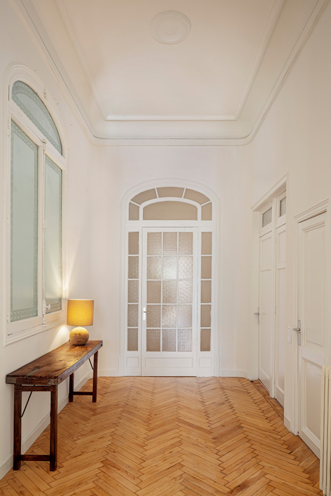 Пример оригинального дизайна: большое фойе в современном стиле с желтыми стенами, светлым паркетным полом, одностворчатой входной дверью, белой входной дверью, коричневым полом и кессонным потолком