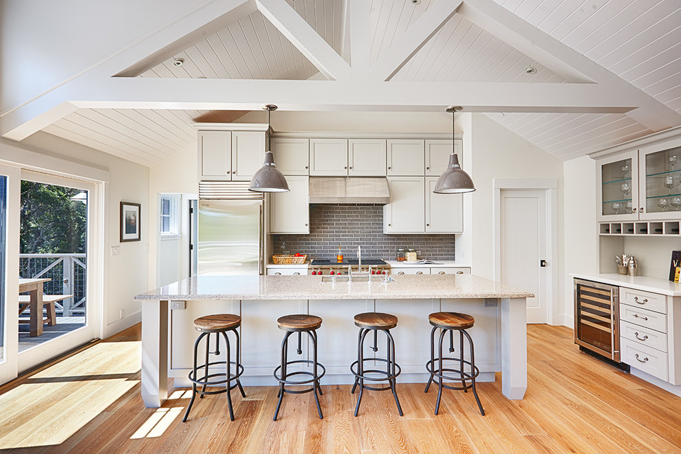 Inspiration for a country kitchen in San Francisco with an undermount sink, shaker cabinets, white cabinets, grey splashback, subway tile splashback, stainless steel appliances, light hardwood floors and with island.