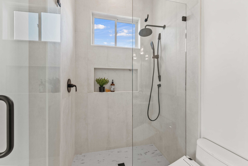 Inspiration för ett mycket stort funkis vit vitt badrum med dusch, med våtrum, en toalettstol med hel cisternkåpa, vit kakel, porslinskakel, vita väggar, klinkergolv i porslin, ett undermonterad handfat, bänkskiva i akrylsten, flerfärgat golv, dusch med gångjärnsdörr, möbel-liknande och grå skåp