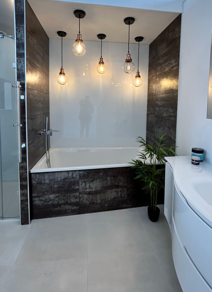 This is an example of a large eclectic master bathroom in Berkshire with flat-panel cabinets, white cabinets, a drop-in tub, an alcove shower, a wall-mount toilet, multi-coloured tile, porcelain tile, white walls, porcelain floors, an integrated sink, glass benchtops, grey floor, a hinged shower door, white benchtops, a single vanity, a floating vanity and coffered.