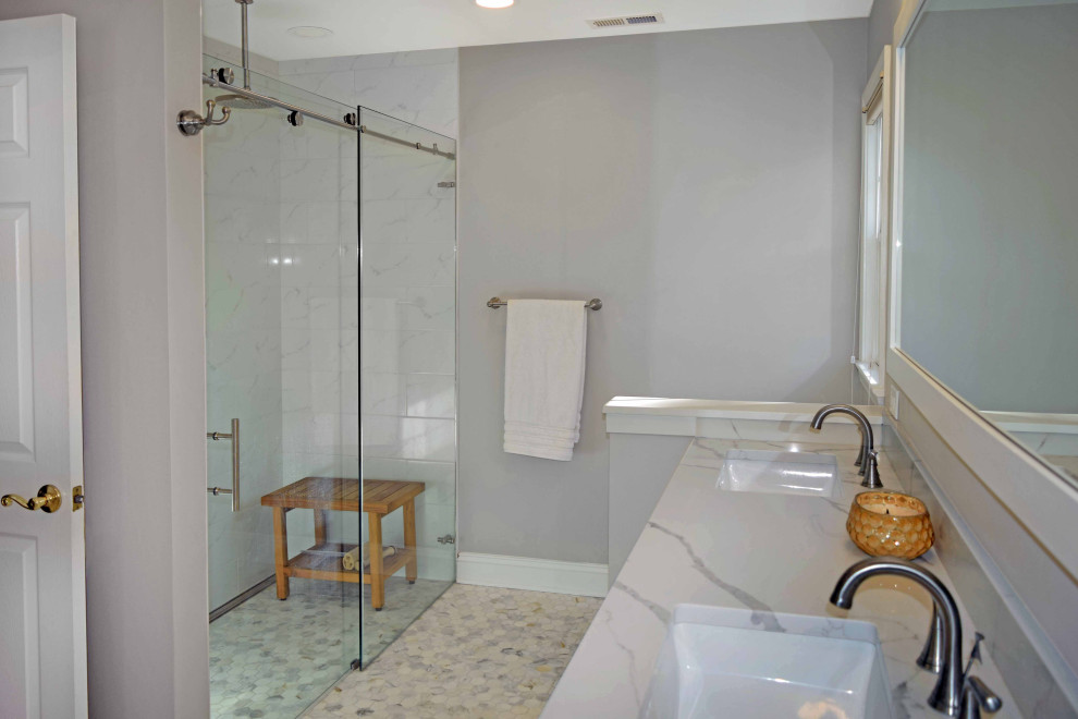 Inspiration for a large contemporary ensuite bathroom in Philadelphia with white cabinets, a freestanding bath, a one-piece toilet, grey tiles, ceramic tiles, grey walls, mosaic tile flooring, a submerged sink, engineered stone worktops, grey floors, white worktops, a wall niche, double sinks, a built in vanity unit and wainscoting.