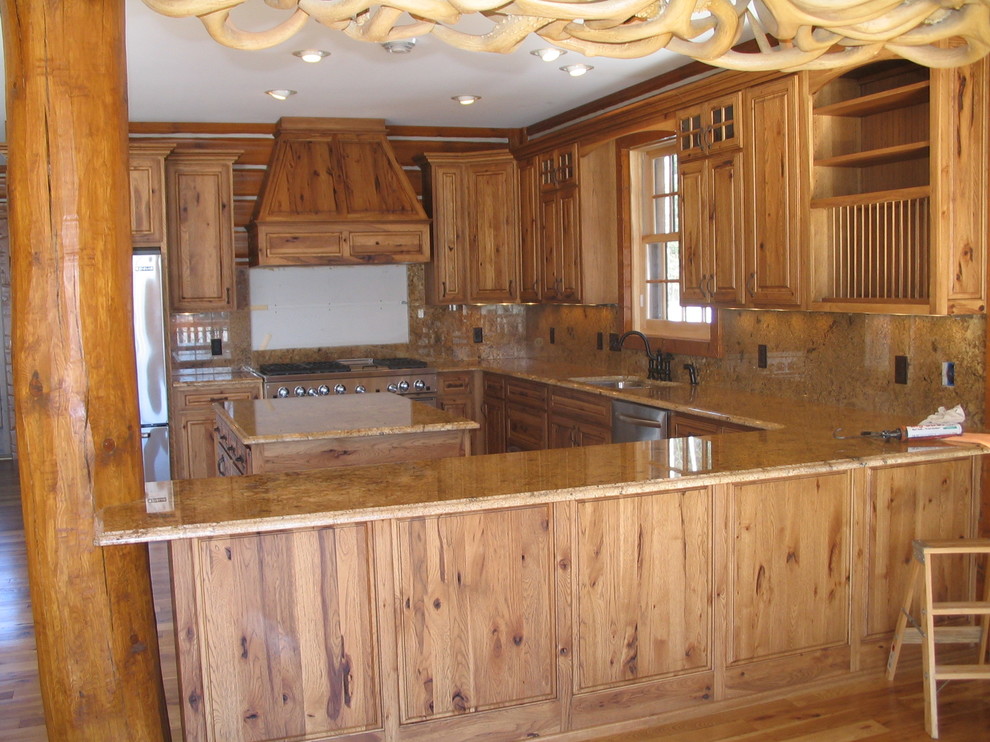 Inspiration for a large rustic u-shaped light wood floor and beige floor enclosed kitchen remodel with an undermount sink, raised-panel cabinets, light wood cabinets, quartz countertops, beige backsplash, porcelain backsplash, stainless steel appliances and a peninsula