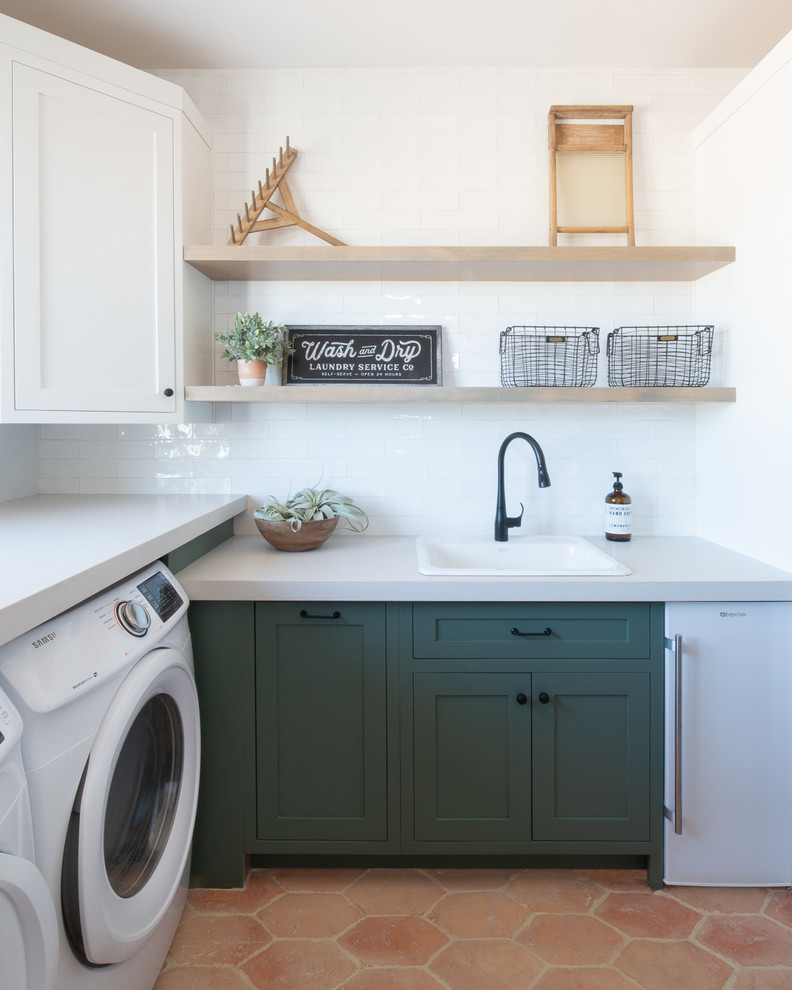 Large country galley dedicated laundry room in Phoenix with a drop-in sink, shaker cabinets, green cabinets, white walls, terra-cotta floors, a side-by-side washer and dryer, orange floor, grey benchtop and concrete benchtops.