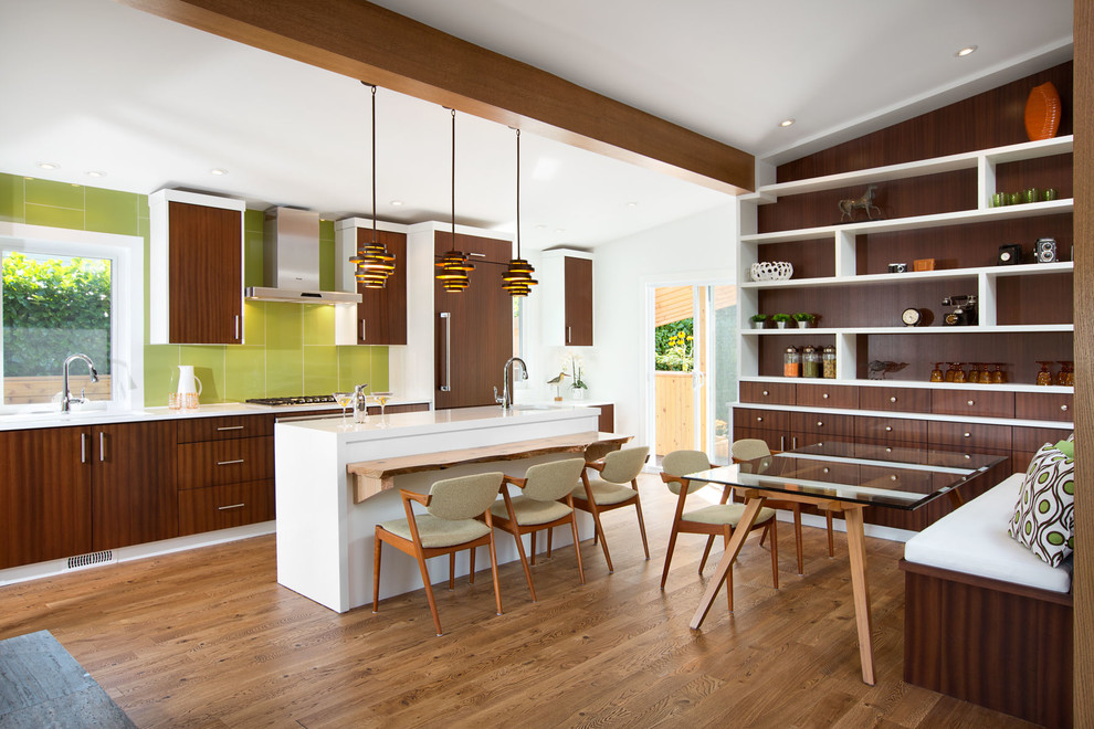 Inspiration for a midcentury galley eat-in kitchen in Vancouver with flat-panel cabinets, dark wood cabinets, green splashback, panelled appliances, medium hardwood floors, with island, an undermount sink, quartz benchtops and glass sheet splashback.