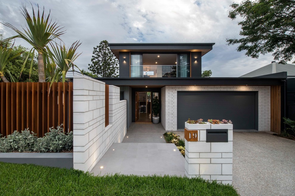 This is an example of a contemporary two-storey grey house exterior in Brisbane with mixed siding and a flat roof.