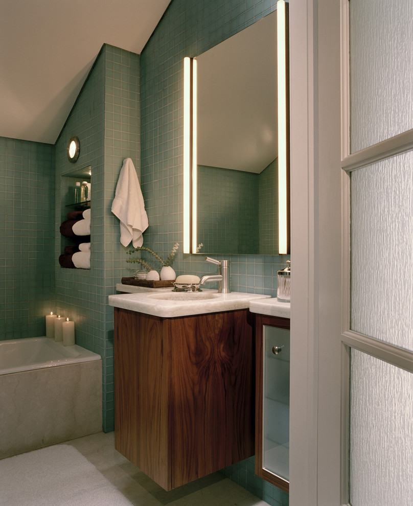 This is an example of a contemporary bathroom in San Francisco with flat-panel cabinets, dark wood cabinets, a drop-in tub and blue tile.