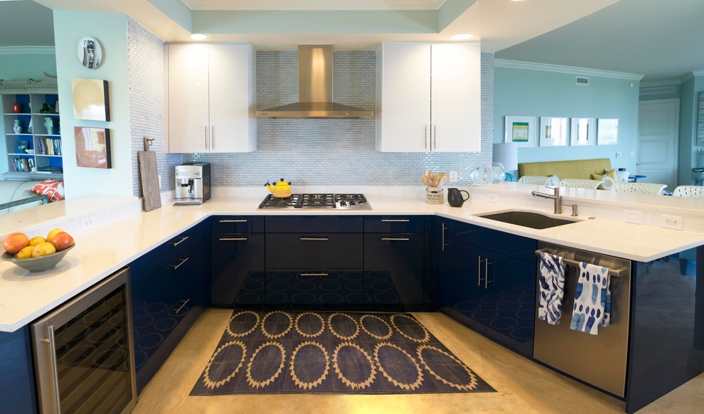 Small contemporary u-shaped open plan kitchen in Miami with flat-panel cabinets, quartz benchtops, blue splashback, stainless steel appliances, no island, an undermount sink, blue cabinets, glass tile splashback, beige floor and laminate floors.