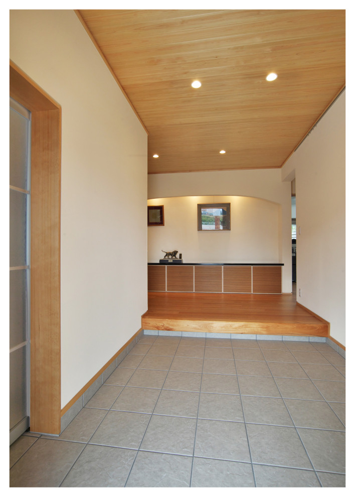 Photo of a large modern entry hall in Other with a sliding front door, a medium wood front door, white walls, medium hardwood floors, beige floor and wood.