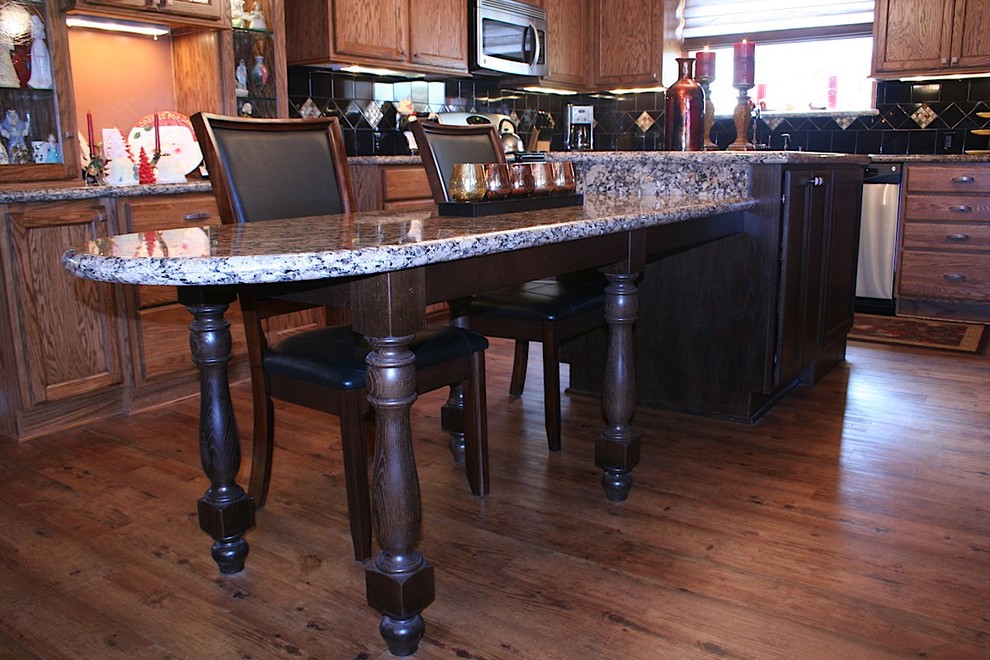 Inspiration for a large timeless u-shaped vinyl floor kitchen remodel with an undermount sink, recessed-panel cabinets, medium tone wood cabinets, granite countertops, black backsplash, ceramic backsplash, stainless steel appliances and an island