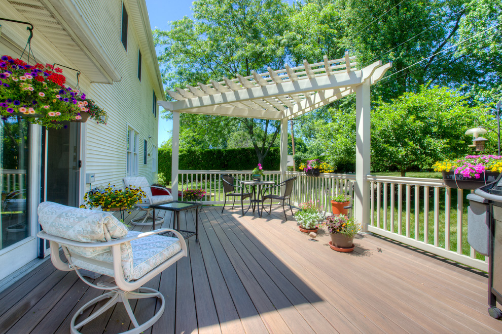 Inspiration for a mid-sized traditional backyard deck in Other with a pergola.