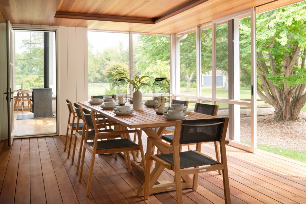 Inspiration for a large cottage screened-in back porch remodel in Boston with a roof extension