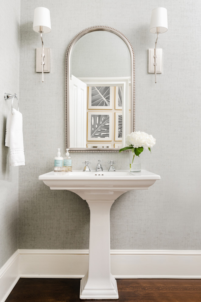 Inspiration for a traditional powder room in Charlotte with grey walls, dark hardwood floors, a pedestal sink and brown floor.