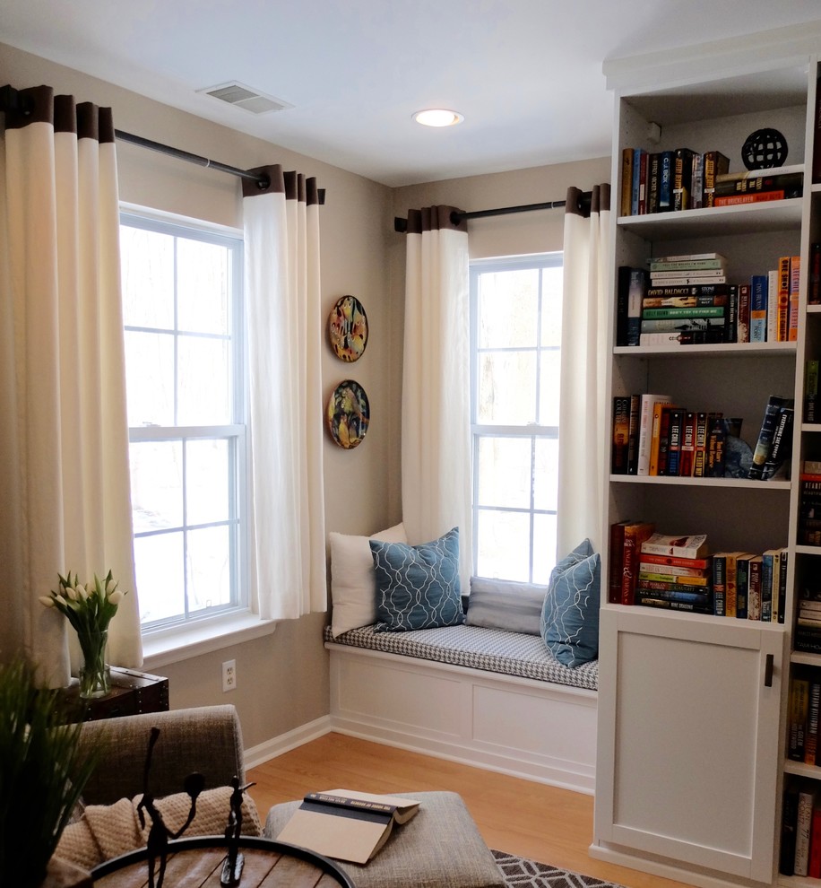 This is an example of a small transitional enclosed living room in New York with a library, beige walls, carpet, no fireplace, no tv and brown floor.