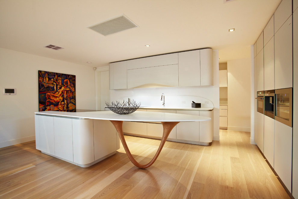 Contemporary u-shaped open plan kitchen in Melbourne with flat-panel cabinets, white cabinets, solid surface benchtops, white splashback and stone slab splashback.