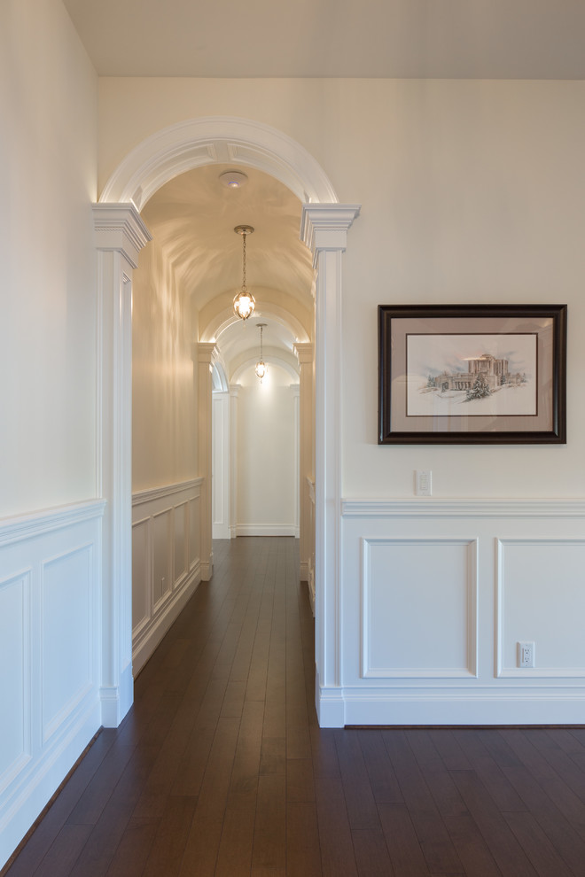 This is an example of a mid-sized traditional foyer in Calgary with white walls, marble floors, a single front door, a dark wood front door and beige floor.