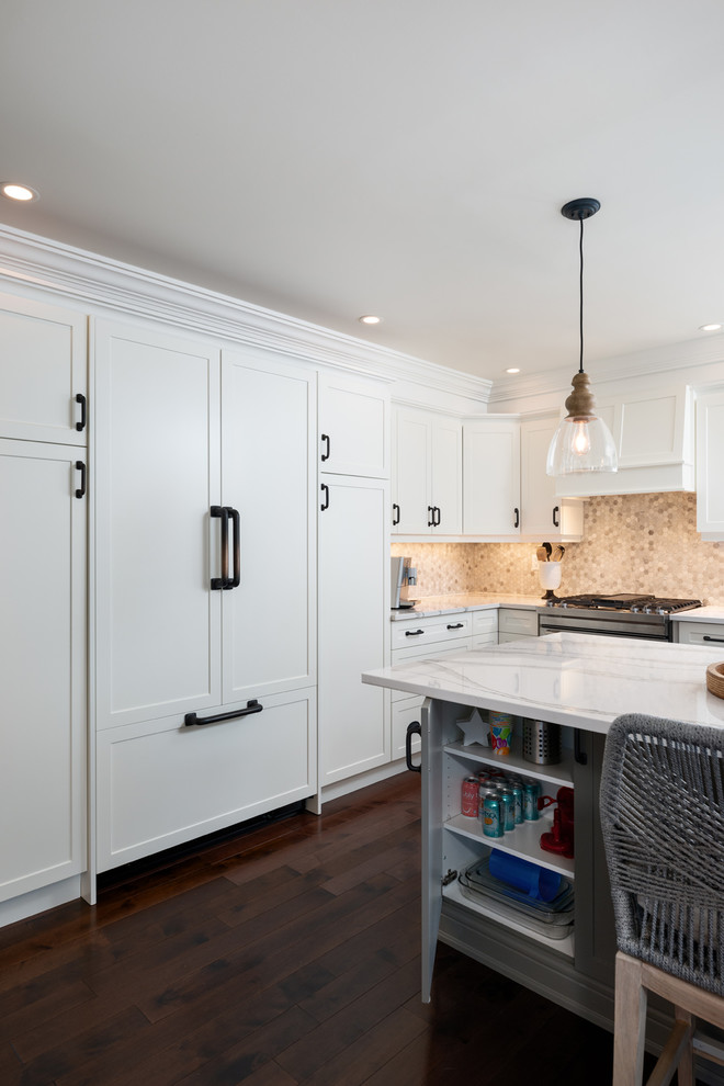 Transitional dark wood floor and brown floor kitchen photo with white cabinets, quartz countertops, paneled appliances, an island and white countertops