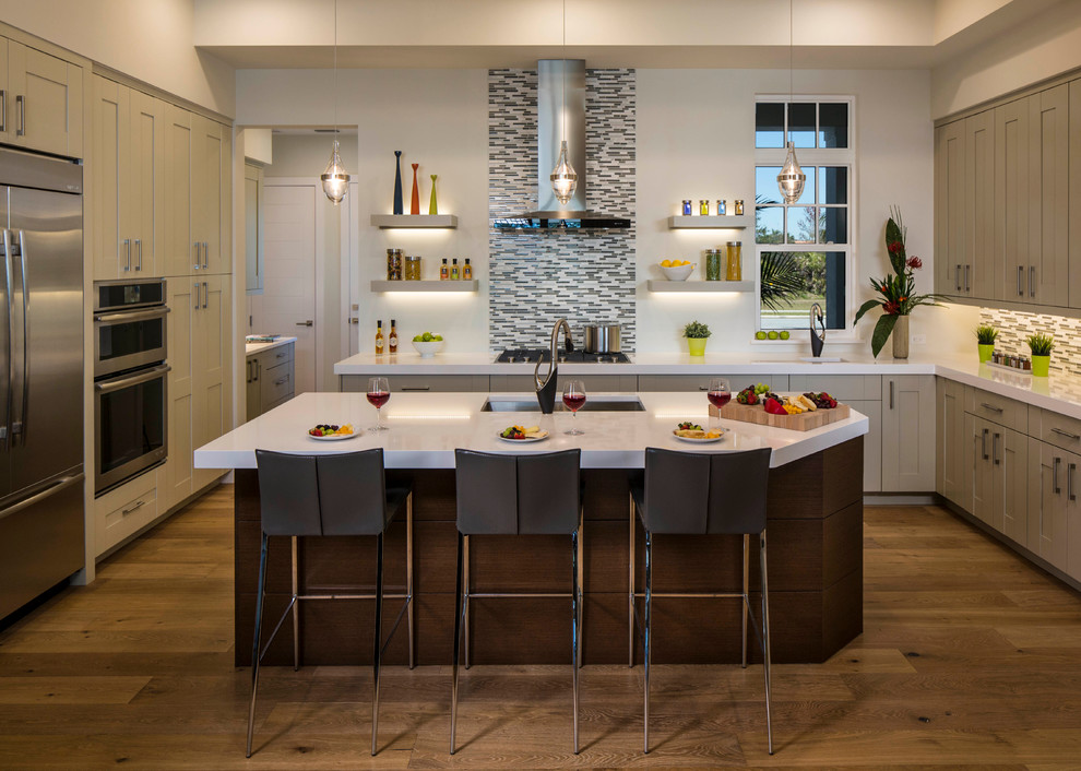 Inspiration for a large transitional u-shaped medium tone wood floor kitchen remodel in Tampa with an undermount sink, shaker cabinets, beige cabinets, multicolored backsplash, matchstick tile backsplash, stainless steel appliances and an island