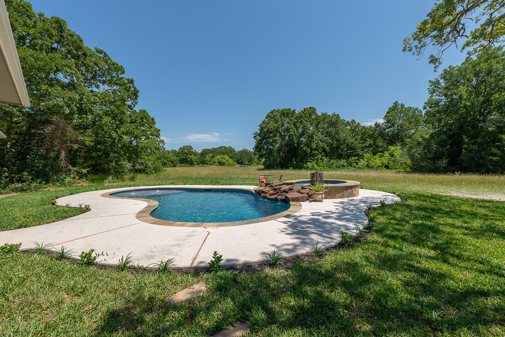 Mid-sized mountain style backyard stone and custom-shaped natural hot tub photo