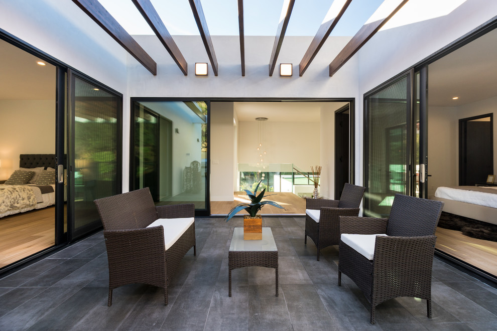 This is an example of a contemporary courtyard patio in Los Angeles with a pergola.
