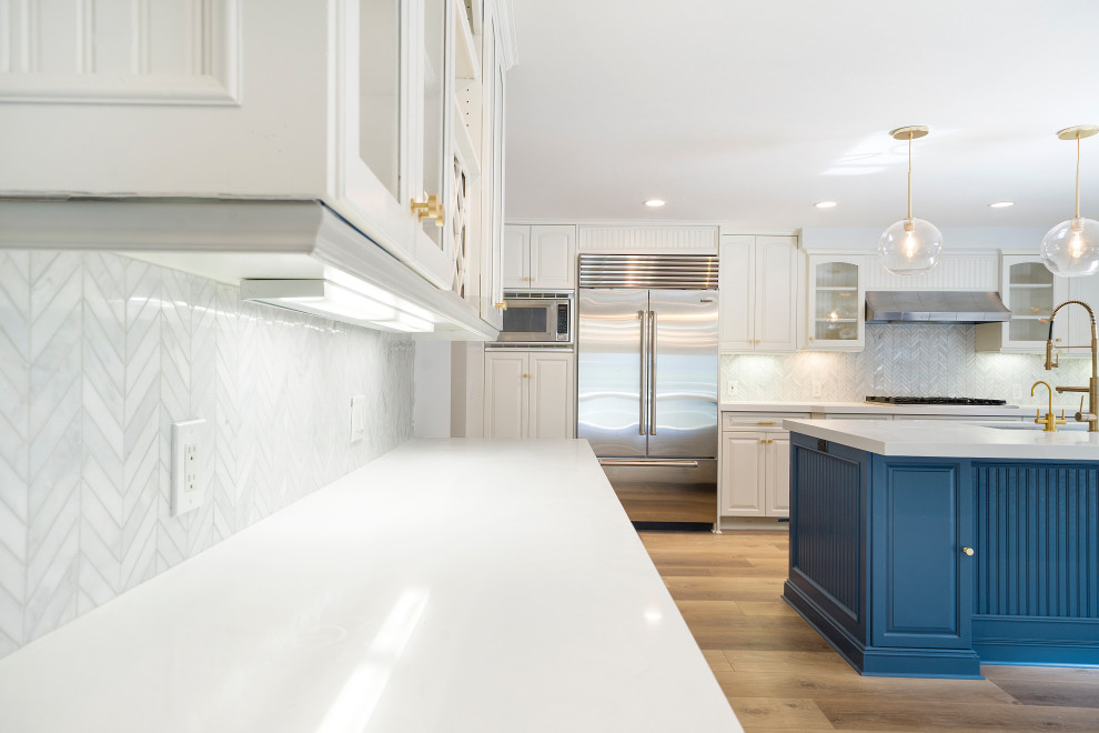 Mid-sized transitional laminate floor and brown floor eat-in kitchen photo in Orange County with an undermount sink, shaker cabinets, blue cabinets, quartz countertops, white backsplash, mosaic tile backsplash, stainless steel appliances, an island and white countertops