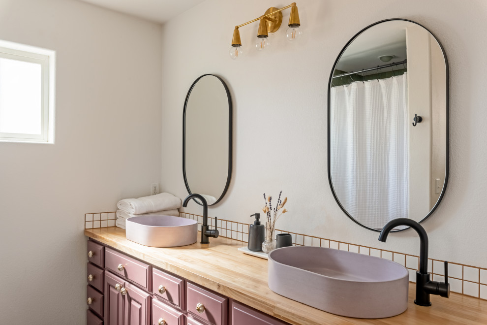 Cette photo montre une salle de bain principale moderne avec un placard avec porte à panneau surélevé, des portes de placard violettes, une douche ouverte, un carrelage blanc, des carreaux de céramique, un mur blanc, un sol en ardoise, une vasque, un plan de toilette en bois, un sol noir, une cabine de douche avec un rideau, un plan de toilette marron, meuble double vasque et meuble-lavabo encastré.