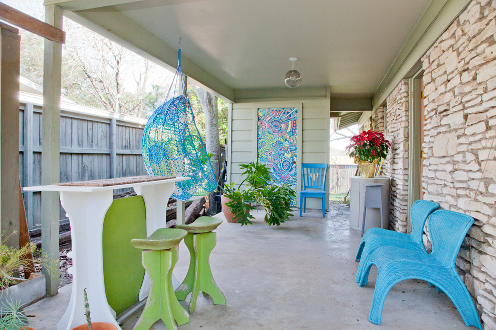 This is an example of an eclectic patio in Austin with a roof extension.