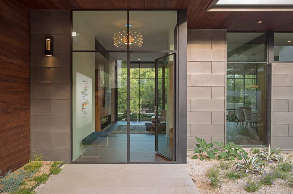 Photo of a mid-sized contemporary front door in Austin with a single front door, a metal front door, beige walls, medium hardwood floors and brown floor.