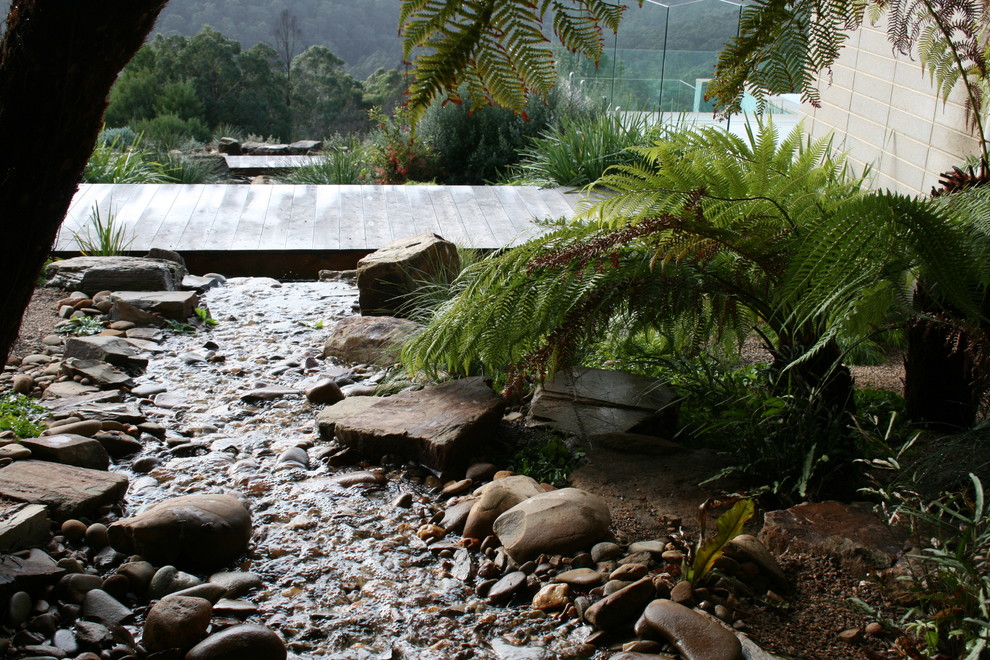 Inspiration for a large country sloped full sun xeriscape in Geelong with a water feature and natural stone pavers.